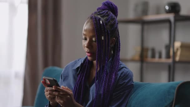 Wanita kulit hitam muda sedang mengobrol melalui telepon genggam, mengirimkan pesan dalam jaring sosial, internet berselancar, potret wanita — Stok Video