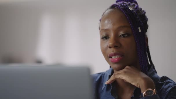 Jovem mulher negra está se comunicando por videochamada on-line no laptop, consultora feminina de suporte técnico, olhando para a câmera da web e conversando — Vídeo de Stock
