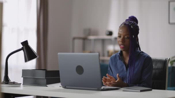 Comunicação on-line por videochamada no laptop, mulher negra está conversando com colegas durante reunião de negócios distante, trabalhando em casa — Vídeo de Stock