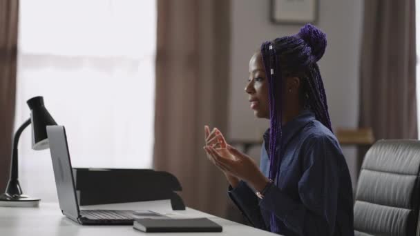 Fiatal fekete nő beszél online video hívás notebook, nézi a képernyőn, és válaszol a kérdésekre, távoli üzleti találkozó — Stock videók