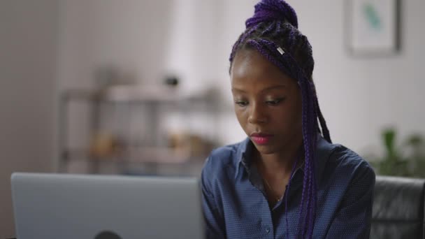 Az afro-amerikai nő gépel a laptopján, szörfözik az interneten és közösségi hálókon kommunikál. — Stock videók