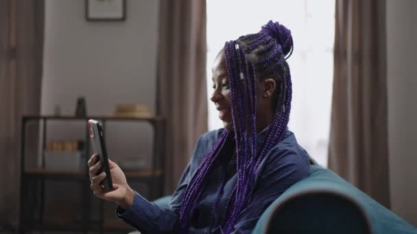 Afro-amerikaanse vrouw glimlacht breed bij het communiceren via video chat met vriend of vriend — Stockvideo
