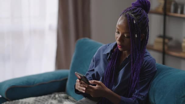 Black teen girl is sending messages in social nets by smartphone, modern technology for communicating — Stock Video