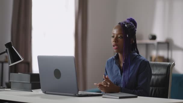 Jovem mulher negra está se comunicando on-line por chamada de vídeo em notebook, consultor do sexo feminino está trabalhando em casa — Vídeo de Stock