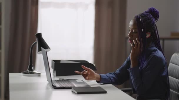여성 사무직 근로자가 휴대폰으로 고객 과 상담하고 책상에 앉아서 노트북으로 이야기하고 사진을 찍고 있습니다. — 비디오