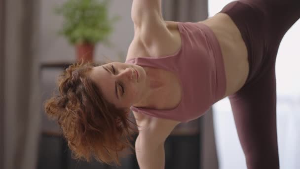 Dospělá hezká žena cvičí hatha jógu doma, provádí asana pro rovnováhu a vytrvalost, ranní fyzické cvičení — Stock video