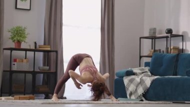 Güzel bir kadın sabah spor yapıyor, oturma odasında sabah antrenmanı yapıyor, yetişkin bir kadın fiziksel egzersiz yapıyor.