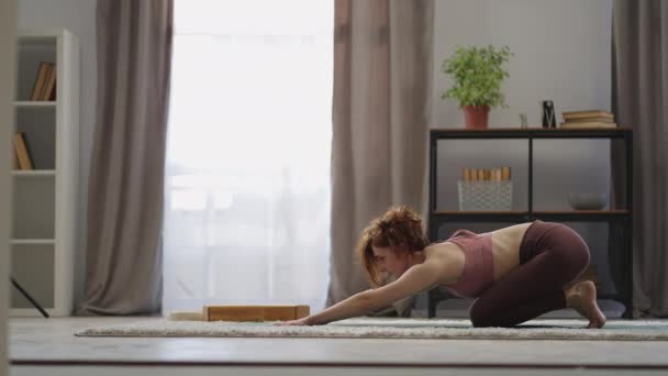 날씬 한 여자는 아침에 집에서 운동을 하면서 혼자 서 훈련을 받고 있다 — 비디오