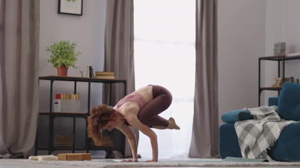 Deportiva mujer fuerte está haciendo handstand, practicando yoga en apartamento, realizando asana para el equilibrio y la fuerza — Vídeos de Stock