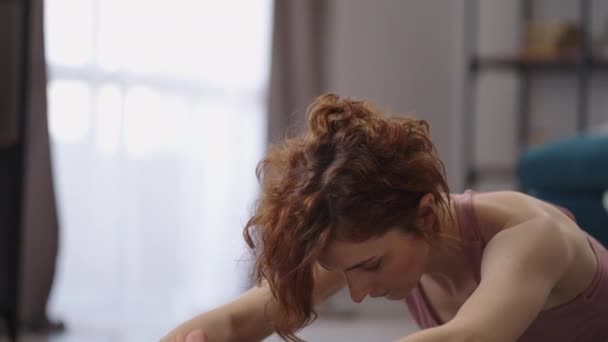 Donna si prende cura della sua salute e la figura, la formazione a casa al mattino ogni giorno, facendo esercizi per lo stretching — Video Stock