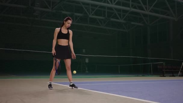 Professionell kvinnlig tennisspelare är klädd sportkläder kastar boll på banan innan servering, fullängds porträtt — Stockvideo