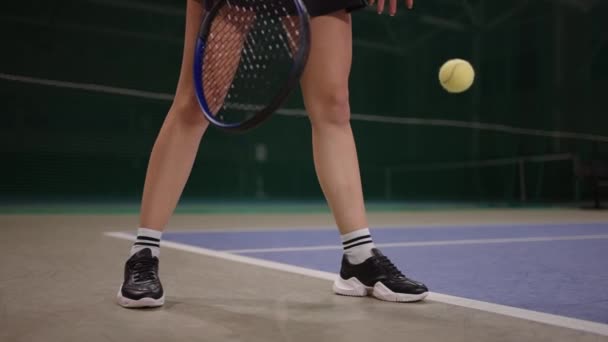 Gambe sottili di tennista professionista femminile in campo all'inizio della partita, la signora sta lanciando palla sul pavimento — Video Stock