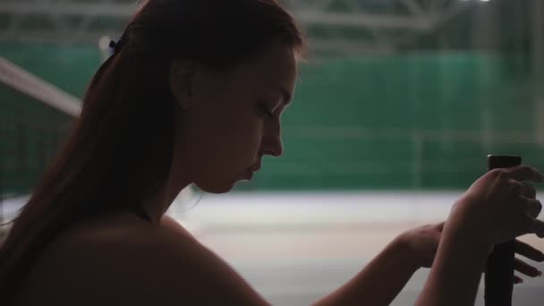 Ung idrottskvinna sitter nära nätet på tennisbanan efter förlorad match, vrida racket och tänka på misslyckande, närbild porträtt — Stockvideo