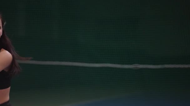 Retrato de una joven jugadora de tenis bastante femenina en la cancha, golpeando la pelota por raqueta, cámara lenta dentro del juego — Vídeos de Stock