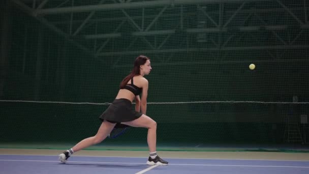 Professionell kvinnlig tennisspelare tränar på banan, slå bollen med racket, full längd slow motion — Stockvideo