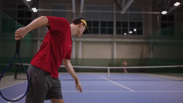 Професійний тенісист служить м'ячем для жіночого суперника в тенісному корті, повільний рух спортсмена — стокове відео