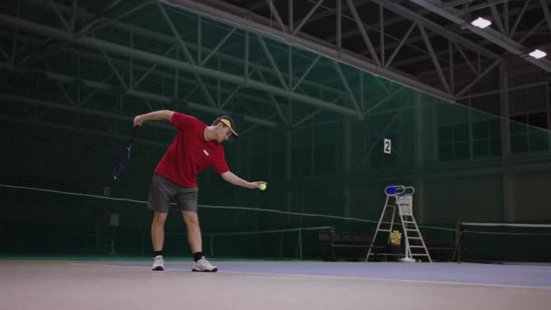 Służyć profesjonalnego tenisisty na krytym korcie tenisowym, szkolenia i ćwiczenia strajki rakietowe, pełnej długości — Wideo stockowe