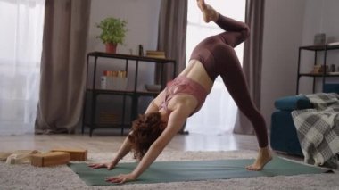 Kadınlar Eka pada adho mukha shvanasana 'yı icra ediyor. Odada hatha yoga yapıyor.