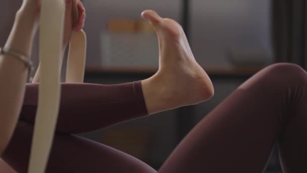Kvinna tränar med elastiskt band, stretching ben, liggande på golvet, närbild, fysisk träning för hälsa — Stockvideo