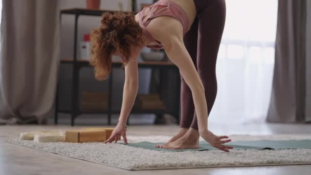 Ejercicios matutinos y gimnasia para la flexibilidad del cuerpo, la mujer está estirando los músculos, de pie en la habitación — Vídeos de Stock