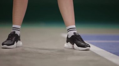 Sahada servis yapılmadan önce bayan tenisçinin bacakları, ayak izlerine yakından bakmak spor ayakkabıları, tenis maçı.