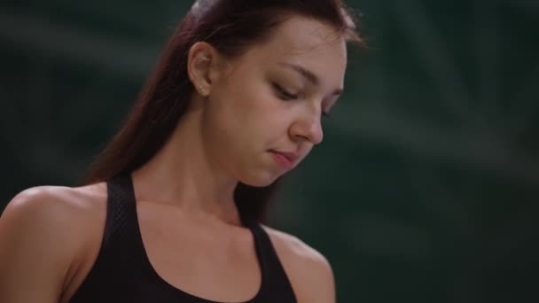 Retrato de una joven jugadora de tenis antes de servir en la cancha, partido de tenis o entrenamiento de una jugadora, tiro de retrato — Vídeo de stock