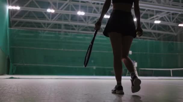 Femme sportive marche sur le court de tennis à l'intérieur, lancer la balle et attraper, vue arrière, entraînement sportif professionnel — Video