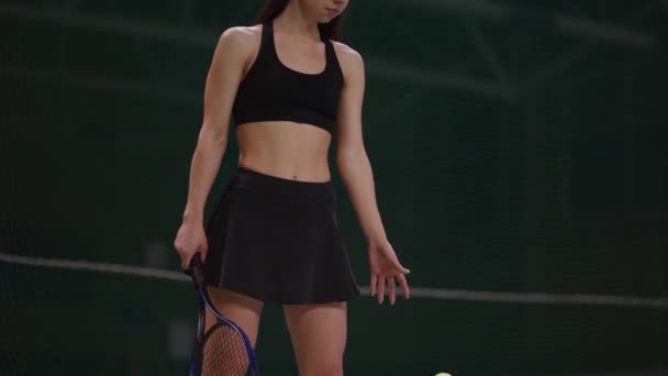 Donna atletica sta lanciando palla sul campo da tennis prima di servire, ritratto girato al chiuso, stile di vita sportivo e attivo — Video Stock