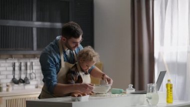 Baba ve bebek mutfakta yemek pişirip oynuyorlar, birlikte vakit geçiriyorlar, mutlu aile hafta sonları.