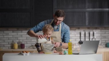 Baba ve küçük oğlu krep hamuru için un seçiyorlar, hafta sonları evde birlikte yemek pişiriyorlar.