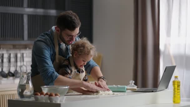 Egyedülálló apa a kisfiával gyúrnak tésztát az otthoni konyhában, apa tanul gyereket főzni és szórakozni — Stock videók