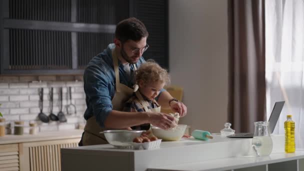 Dorosły mężczyzna i jego mały syn przygotowują niespodziankę dla matki, przygotowując wspólnie śniadanie w kuchni — Wideo stockowe