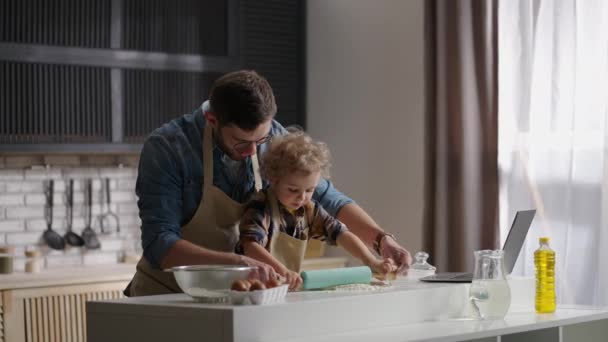 Momenti felici dell'infanzia, il bambino passa del tempo con suo padre in cucina, stendendo la pasta, cucinando insieme — Video Stock