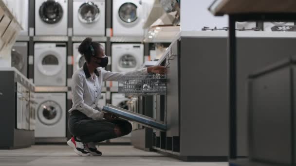Černošky žena je nákup zařízení pro domácí kuchyni, africký Američan dáma je prohlížení myčka nádobí — Stock video