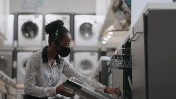 Afrikaans-Amerikaanse huisvrouw kiest vaatwasser in winkel, deur openen en binnen kijken — Stockvideo