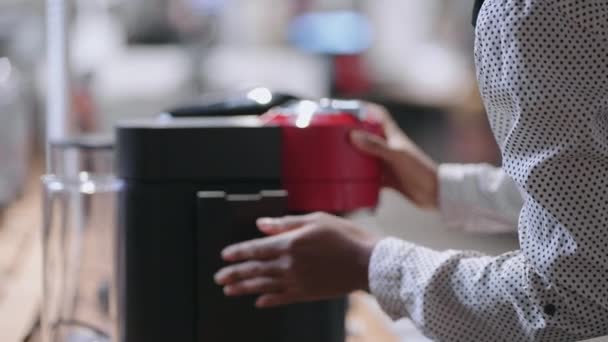 Афро-американская женщина выбирает автоматический кофеварка для дома или офиса, крупный план рук женщины-покупателя — стоковое видео