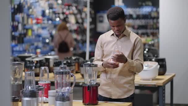 Männliche Shopper wählt Mixer im Geschäft, Anzeige Ausstellung Proben auf Vitrine, schwarzer Kerl ist im Geschäft für Küchengeräte einkaufen — Stockvideo