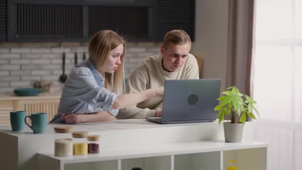 Casal jovem grave segurando papéis pagar contas domésticas on-line no laptop verificando conta bancária ler documento em casa, orçamento de planejamento familiar milenar discutir as despesas de finanças do dinheiro. — Vídeo de Stock