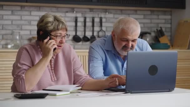 Yaşlı erkek ve kadın telefon yoluyla mali ve sigorta danışmanına danışıyor, kadın telefonla konuşuyor — Stok video