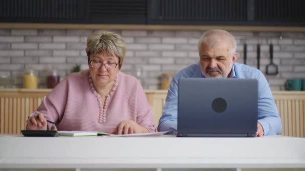 Vecchio e donna stanno contando i loro soldi e budget, due anziani sono seduti insieme in cucina e calcolano i pagamenti — Video Stock