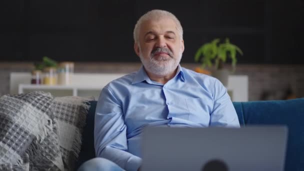 Aged man communiceert via online video chat in laptop met collega 's of partners, deelnemer aan remote business meeting — Stockvideo
