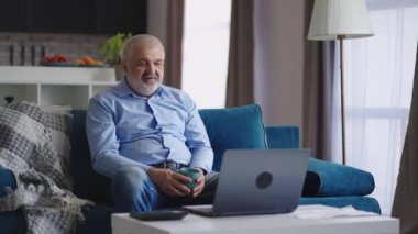 Bekar ve yaşlı bir adam, hafta sonları evinde dinlenen arkadaşları ya da ailesi ile bilgisayardan online görüntülü sohbet yapıyor.