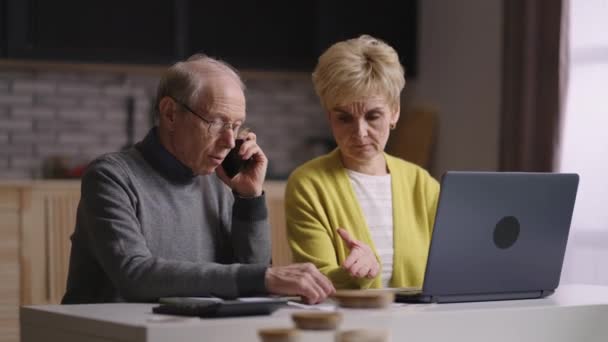 I vecchi pensionati consultano telefonicamente con il consulente finanziario o assicurativo, calcolando insieme il bilancio — Video Stock