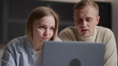 30 'lu yaşlardaki karı koca dizüstü bilgisayarlarıyla mutfaktan e-alışveriş yapıyor, gelecekte taşınmayı planlıyor ve yenileme firmalarını online olarak seçiyor. E-ticaret kolay ve konfor aktivitesi ev kavramından
