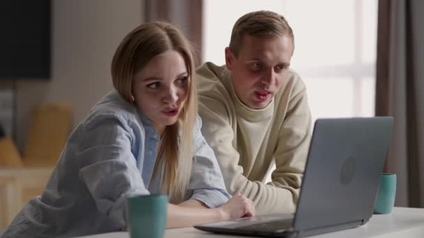 Evli çift mutfakta oturup internet ve dizüstü bilgisayar kullanarak video görüşmesi yapıyor. Uzaktan iletişim, aile ile keyifli video konferans sohbeti. Modern teknoloji, uygulamalar kullanım kavramı — Stok video