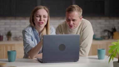 Laptop ekranına bakan, internet alışverişinde yer alan ürünleri seçen, tatil için otel ya da uçak biletlerini bilgisayar üzerinden ayırtmayı tartışan milenyum çifti.