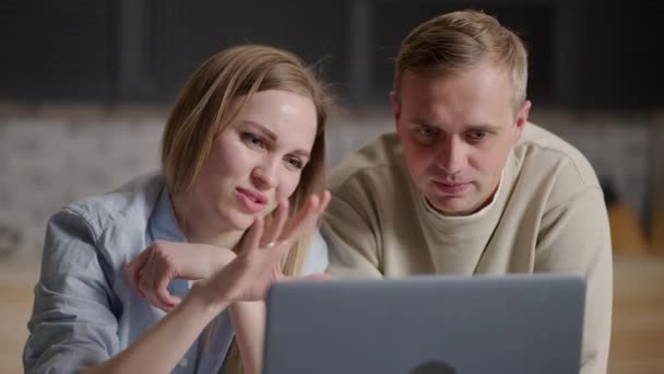 这对年轻夫妇周末在厨房里用笔记本电脑上网，讨论网上订餐，享受轻松舒适的电子商务服务，在网上搜索更新的想法 — 图库视频影像