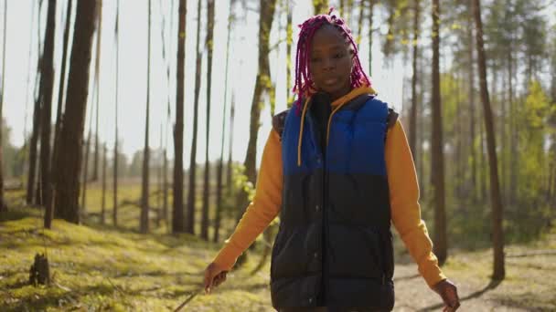 Escursionista africana zaino in spalla nero donna in escursione avventura sensazione di libertà passeggiando nella foresta, Femmina godere le sue vacanze vicino a un sacco di albero. Rallentatore — Video Stock