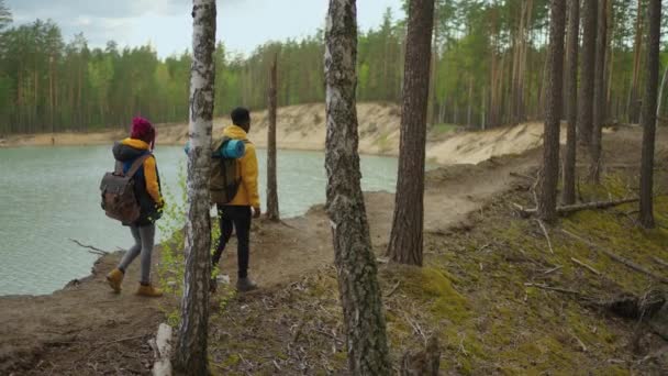 远足的人。徒步旅行的两个非洲男人和女人在山上。两名黑人男女徒步旅行者背着背包走过森林小路。慢动作 — 图库视频影像