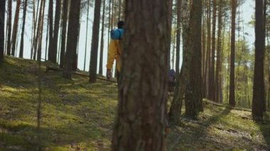 Çekici modern turistler orman tepelerine tırmanan siyah çift uzaktan hayvanları izliyor. Doğal park. Eğlence konsepti. Yavaş çekim yürüyüşü